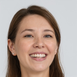 Joyful white young-adult female with long  brown hair and grey eyes