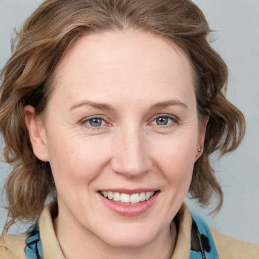 Joyful white young-adult female with medium  brown hair and blue eyes