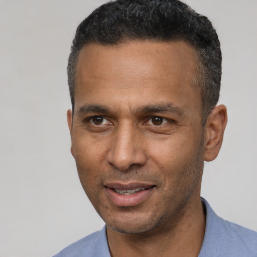 Joyful latino adult male with short  black hair and brown eyes