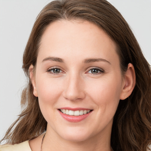 Joyful white young-adult female with long  brown hair and grey eyes