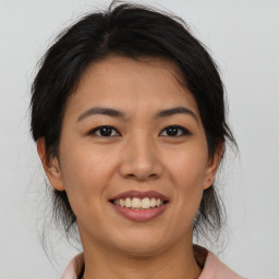 Joyful asian young-adult female with medium  brown hair and brown eyes