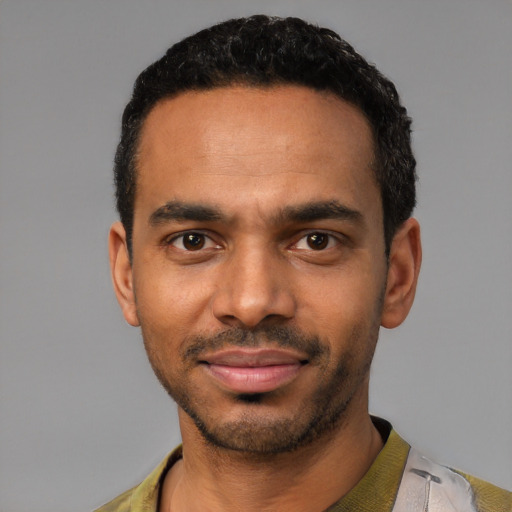 Joyful black young-adult male with short  black hair and brown eyes