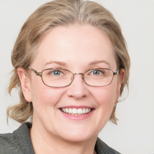 Joyful white adult female with medium  brown hair and blue eyes