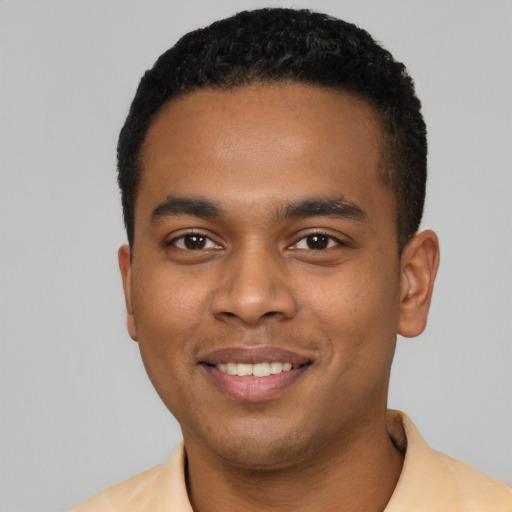 Joyful black young-adult male with short  black hair and brown eyes