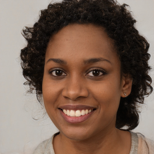Joyful black young-adult female with medium  brown hair and brown eyes