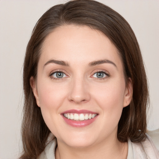 Joyful white young-adult female with medium  brown hair and grey eyes