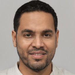 Joyful latino young-adult male with short  black hair and brown eyes