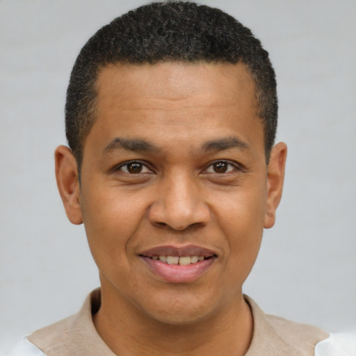 Joyful black young-adult male with short  brown hair and brown eyes