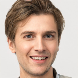 Joyful white young-adult male with short  brown hair and grey eyes