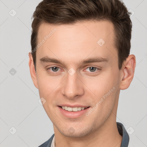 Joyful white young-adult male with short  brown hair and grey eyes