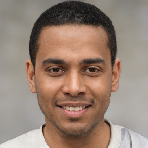 Joyful black young-adult male with short  black hair and brown eyes