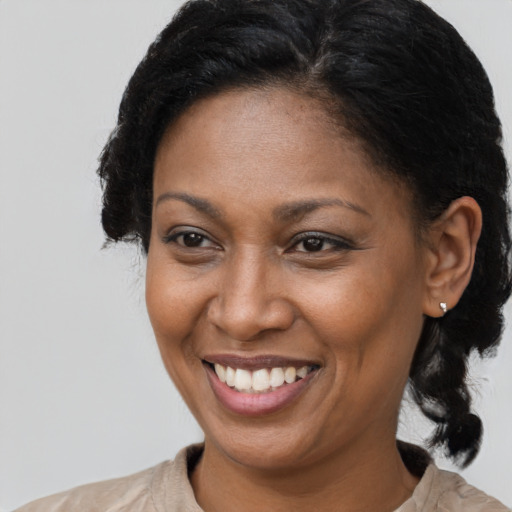 Joyful black adult female with medium  brown hair and brown eyes