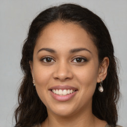 Joyful latino young-adult female with long  brown hair and brown eyes