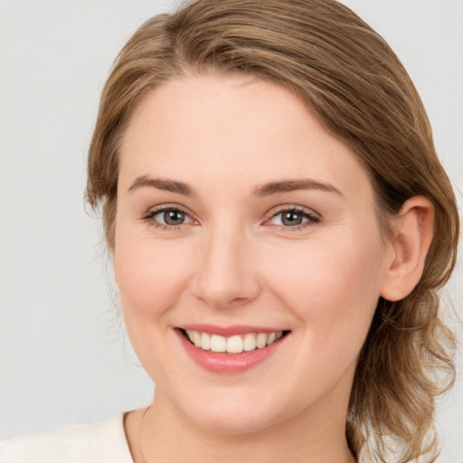 Joyful white young-adult female with medium  brown hair and blue eyes