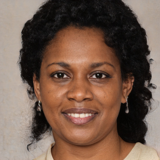 Joyful black adult female with medium  black hair and brown eyes