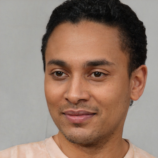 Joyful latino young-adult male with short  black hair and brown eyes
