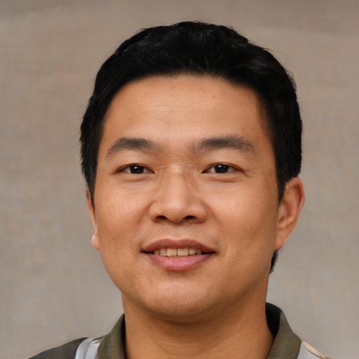 Joyful asian young-adult male with short  black hair and brown eyes