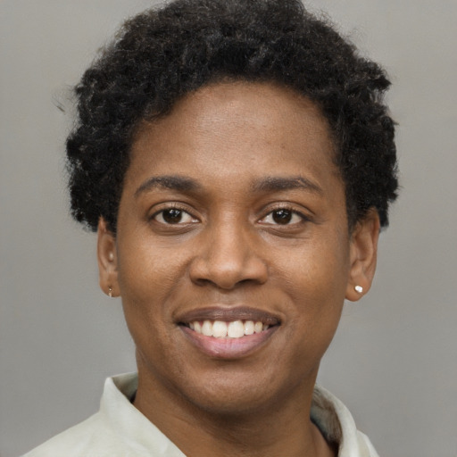 Joyful black young-adult male with short  brown hair and brown eyes