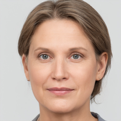 Joyful white adult female with medium  brown hair and grey eyes