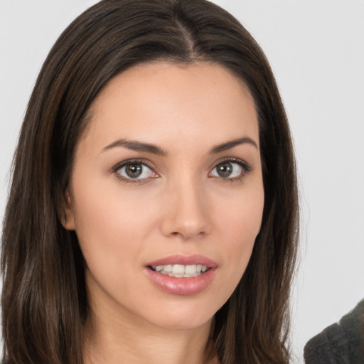 Joyful white young-adult female with long  brown hair and brown eyes