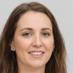 Joyful white young-adult female with long  brown hair and green eyes