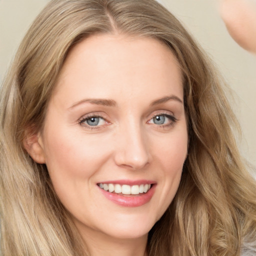 Joyful white young-adult female with long  brown hair and blue eyes