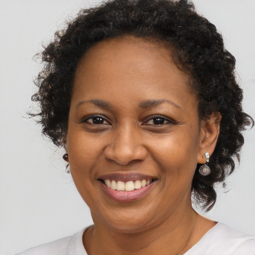 Joyful black adult female with medium  brown hair and brown eyes