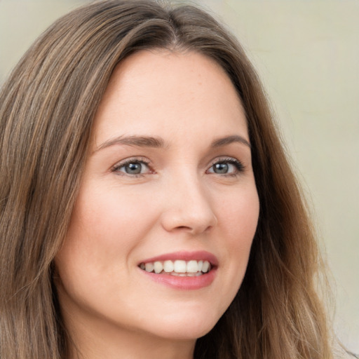 Joyful white young-adult female with long  brown hair and green eyes