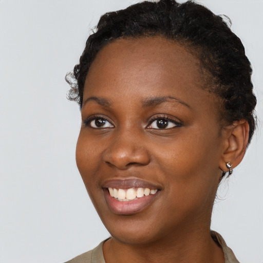 Joyful black young-adult female with short  black hair and brown eyes