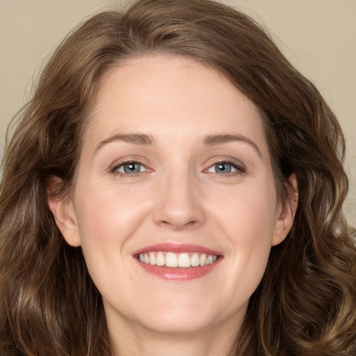 Joyful white young-adult female with long  brown hair and green eyes