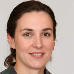 Joyful white adult female with medium  brown hair and grey eyes