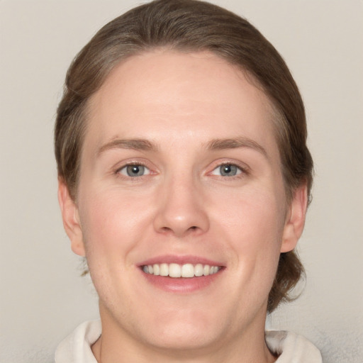 Joyful white young-adult female with short  brown hair and grey eyes