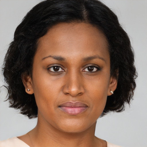 Joyful black young-adult female with long  brown hair and brown eyes
