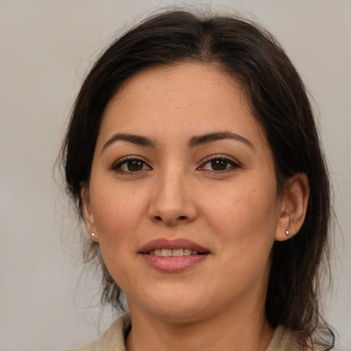 Joyful latino young-adult female with medium  brown hair and brown eyes