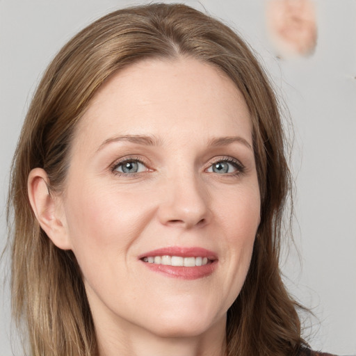 Joyful white young-adult female with long  brown hair and blue eyes