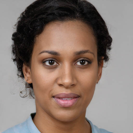 Joyful black young-adult female with short  brown hair and brown eyes