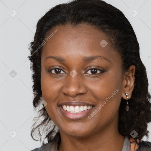 Joyful black young-adult female with long  brown hair and brown eyes