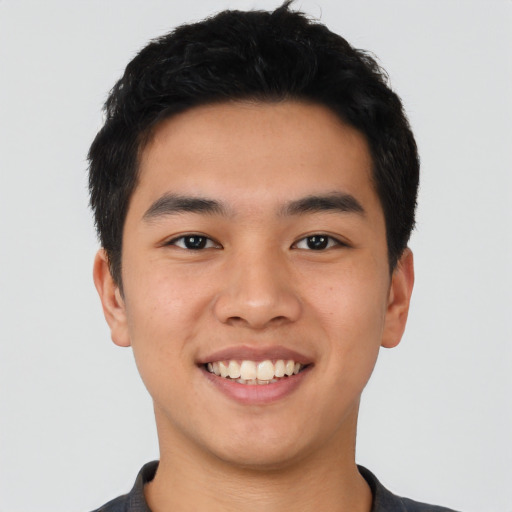 Joyful asian young-adult male with short  black hair and brown eyes