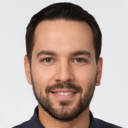 Joyful white young-adult male with short  black hair and brown eyes