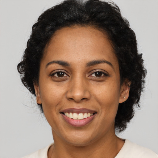 Joyful latino adult female with short  black hair and brown eyes