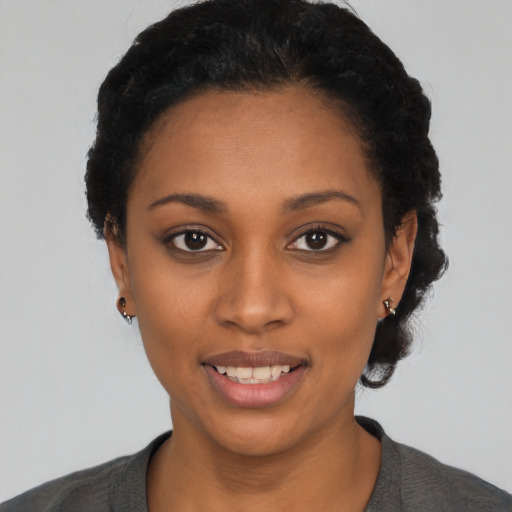 Joyful black young-adult female with short  black hair and brown eyes