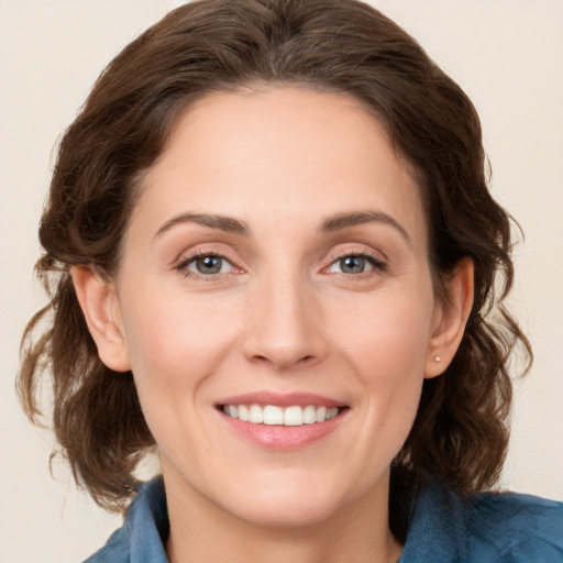 Joyful white young-adult female with medium  brown hair and grey eyes