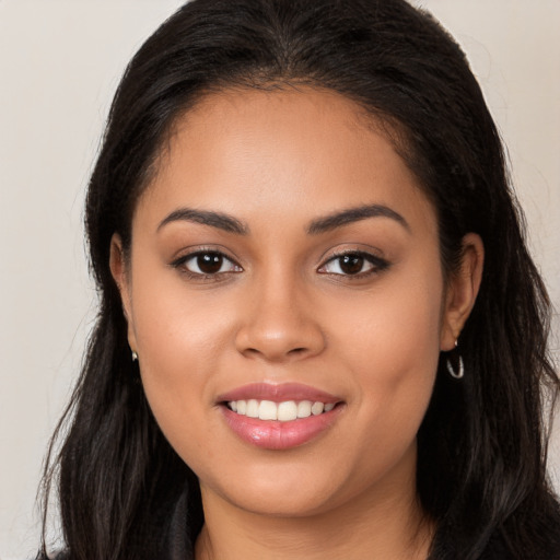 Joyful latino young-adult female with long  brown hair and brown eyes