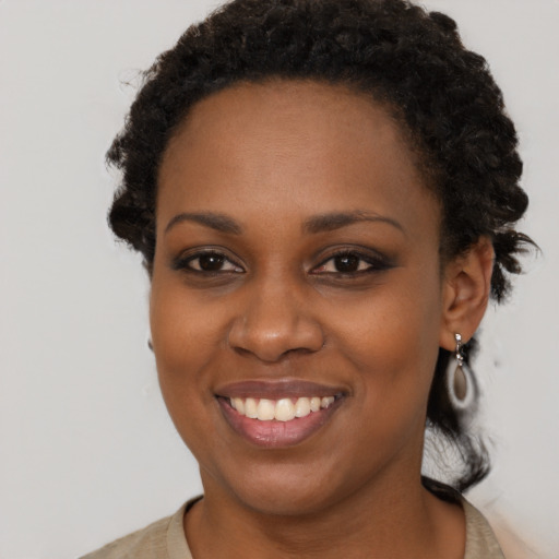 Joyful black young-adult female with short  brown hair and brown eyes