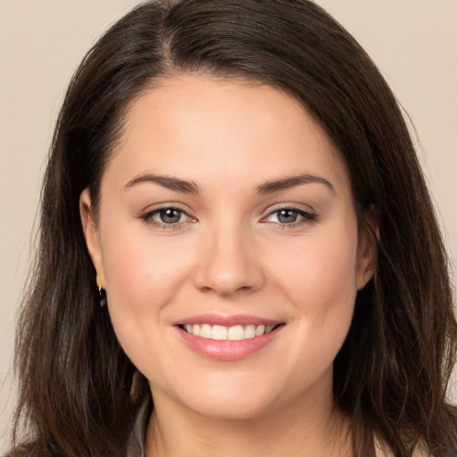 Joyful white young-adult female with long  brown hair and brown eyes