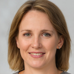 Joyful white adult female with medium  brown hair and grey eyes