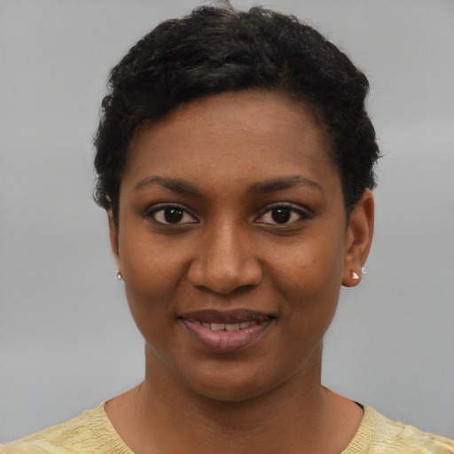 Joyful black young-adult female with short  black hair and brown eyes