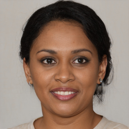 Joyful black young-adult female with medium  brown hair and brown eyes