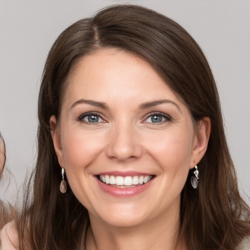 Joyful white young-adult female with long  brown hair and grey eyes