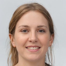 Joyful white young-adult female with medium  brown hair and grey eyes